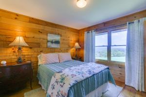 ein Schlafzimmer mit einem Bett mit einer Holzwand in der Unterkunft Stunning Gore Vacation Rental on 10 Acres of Land! 