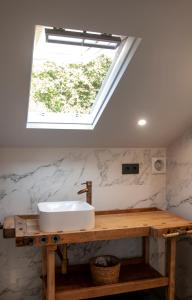 a bathroom with a sink and a skylight at Casa D'Mina in Redondela