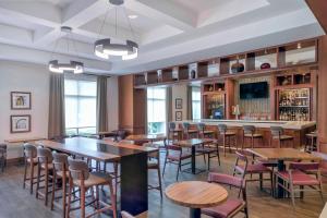 um restaurante com mesas e cadeiras e um bar em DoubleTree by Hilton Raleigh-Cary em Cary