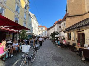 a group of people sitting at tables in a street at Franziskaner Suites #6 in Graz