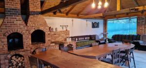 a room with a brick fireplace and tables and chairs at Casa Florea Stanceni in Ciobotani