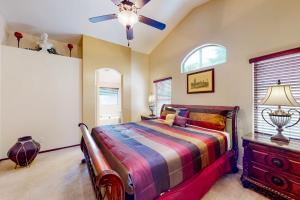 een slaapkamer met een bed en een plafondventilator bij Renee Retreat in Phoenix