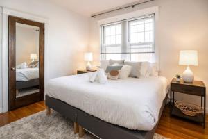 a bedroom with a large white bed and a mirror at Hyde Park Comfort with Office Near Everything in Cincinnati