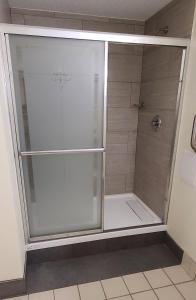 a shower with a glass door in a bathroom at Red Roof Inn & Suites Cornelius - Lake Norman in Cornelius