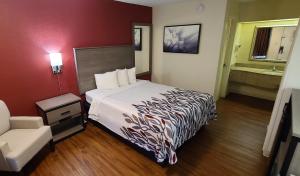 a hotel room with a bed and a bathroom at Red Roof Inn & Suites Cornelius - Lake Norman in Cornelius
