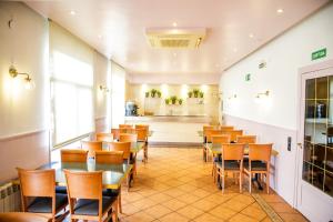 Hotel Can Solé في كامبريلس: مطعم فيه طاولات وكراسي في الغرفة