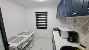 uma cozinha com armários azuis e um balcão branco em Apartament lângă Port Turistic Mangalia 2 camere decomandate, renovat 2023 em Mangalia