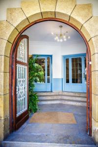 Hotel Can Solé في كامبريلس: مدخل يؤدي إلى منزل بأبواب زرقاء