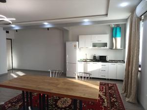 a living room with a table and a kitchen at APARTMENT - КВАРТИРА NEW in Tashkent