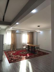 a dining room with a table and chairs on a rug at APARTMENT - КВАРТИРА NEW in Tashkent