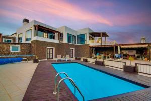 een villa met een zwembad en een huis bij Villa Vista Mar in Yaiza