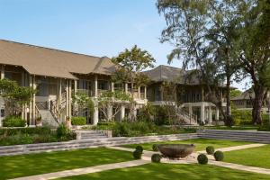 an exterior view of a house with a large yard at CHARRAS Bhawan Hotel and Residences in Hua Hin