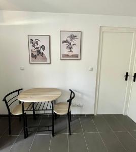 stół i krzesła w pokoju z dwoma zdjęciami na ścianie w obiekcie Le Central : Appartement cosy et calme w mieście Saint-Germain-de-Joux