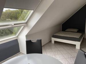 a room with a table and a bed and a window at TraumBude in Mönchengladbach