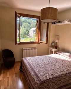 1 dormitorio con cama, ventana y silla en Sallent de Gállego - Formigal - Pirineos Sur, en Sallent de Gállego