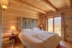 1 dormitorio con 1 cama en una cabaña de madera en Yellowstone Cabin with Stunning Mountain Views, en Livingston
