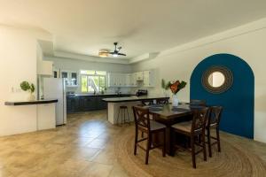 Ivy's Cove Beach Side Condo - Luxury Villa في Whitehouse: مطبخ وغرفة طعام مع طاولة وكراسي