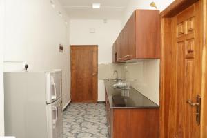 a kitchen with a sink and a refrigerator at Nilo's Guest House in Batticaloa