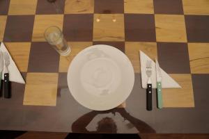 a table with a plate and cutlery on a chessboard at Nilo's Guest House in Batticaloa
