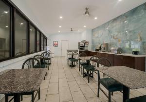 a restaurant with tables and chairs and a counter at Econo Lodge Inn & Suites Fulton - Rockport in Rockport