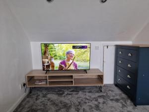 a living room with a flat screen tv on a entertainment center at Victoria Road in Erith