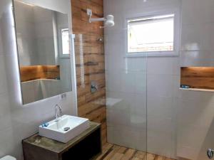 y baño con lavabo y ducha con espejo. en Pousada Eldorado Guarujá o o o o o o o o o o o o o o o o o o o o o o o o o o o o o o o o o o o o o o o o o o o o o o o o o o o o o o o o o o o o o o o, en Guarujá