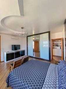 ein Schlafzimmer mit einem blauen Bett und ein Wohnzimmer in der Unterkunft Apartamento Bicho do Mar in Torres