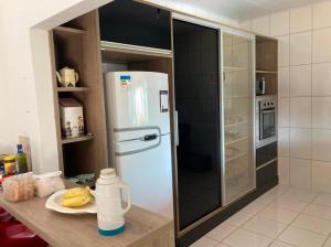 a kitchen with a white refrigerator in a kitchen at Vila agradável e confortável com piscina in Pirenópolis