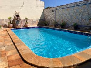 a swimming pool with blue water in a backyard at Vila agradável e confortável com piscina in Pirenópolis