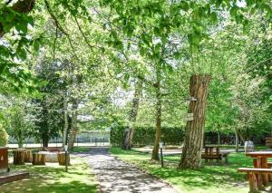 un parc avec des bancs, des tables et des arbres dans l'établissement Demeures de Campagne Château de Fontainebleau, à Fontainebleau