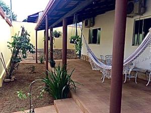 um pátio com cadeiras de rede e uma casa em Vila agradável e confortável com piscina em Pirenópolis