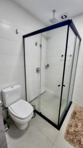 a bathroom with a toilet and a glass shower at Estúdio Luxuoso no Vertigo com Smart TV na Cama in Campo Grande