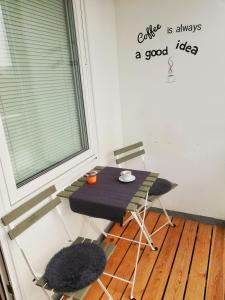 a table and chairs in a room with a writing on the wall at SB Studio in Malmö