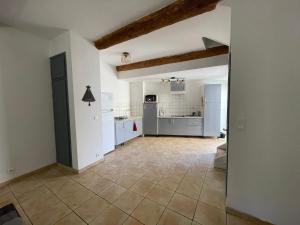 a large kitchen with white cabinets and a tile floor at Appartement cœur de ville aux portes du Luberon in Cavaillon