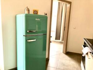 an old green refrigerator in a kitchen with a door at Atelier Loft Bürgel in Bürgel