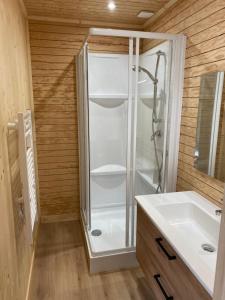 ein Bad mit einer Glasdusche und einem Waschbecken in der Unterkunft La Cabane du Petit Moulin in Bressuire