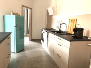uma cozinha com um frigorífico verde e um lavatório em Atelier Loft Bürgel em Bürgel