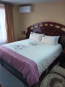 a bedroom with a large bed with a wooden headboard at Prison View Guesthouse 1 in Klerksdorp