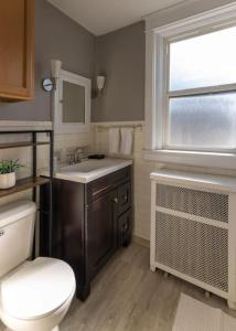 Un baño con inodoro, lavabo y ventana. en Hyde Park Comfort Near Rookwood, en Cincinnati