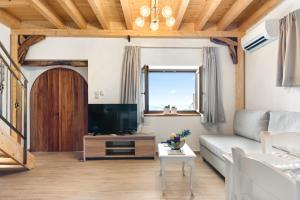 ein Wohnzimmer mit einem Sofa und einem TV in der Unterkunft Myrtillo II Sea View Villa in Spanokhórion