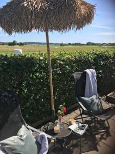 a patio with two chairs and a table with an umbrella at Boende nära havet in Varberg