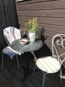 a table and two chairs and a glass of wine on a porch at Boende nära havet in Varberg