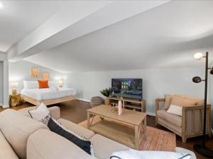 a living room with a couch and a tv at Studio steps to Soccer and OTR and Downtown in Cincinnati