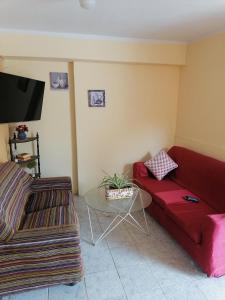 a living room with a red couch and a table at SAN PAOLY. in Trujillo