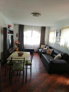ein Wohnzimmer mit einem Sofa und einem Tisch in der Unterkunft SAN PAOLY. in Trujillo