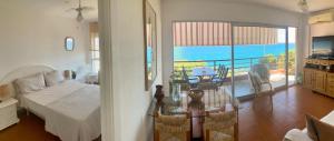 ムンロッチ・ダル・カムにあるMiami playa sirensのリビングルーム(テーブル付)が備わり、海の景色を望めます。