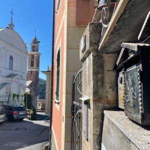 un edificio con una puerta y una calle con una iglesia en Golfo Paradiso Campane di Uscio piccola bomboniera pochi chilometri Camogli Portofino Santamargherita, en Uscio