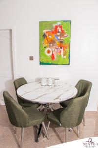 uma mesa de jantar com cadeiras e um quadro em Benteh 2 em Banjul