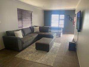 uma sala de estar com um sofá e uma televisão em Riekert's Self-Catering Apartment @Silver Sands em Swakopmund