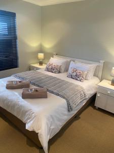 Riekert's Self-Catering Apartment @Silver Sands في سواكوبموند: غرفة نوم بسرير كبير وعليها شنطتين